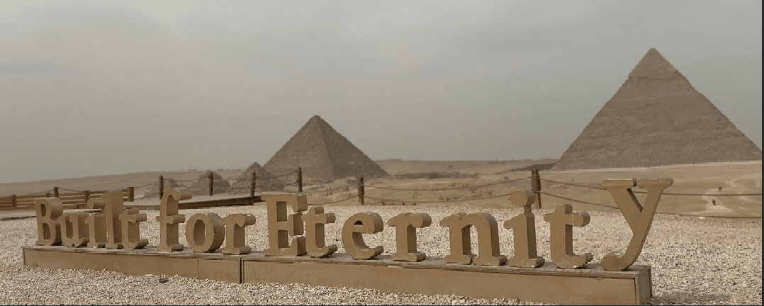 Giza Pyramids view from Khufu Restaurant with Built for Eternity sign