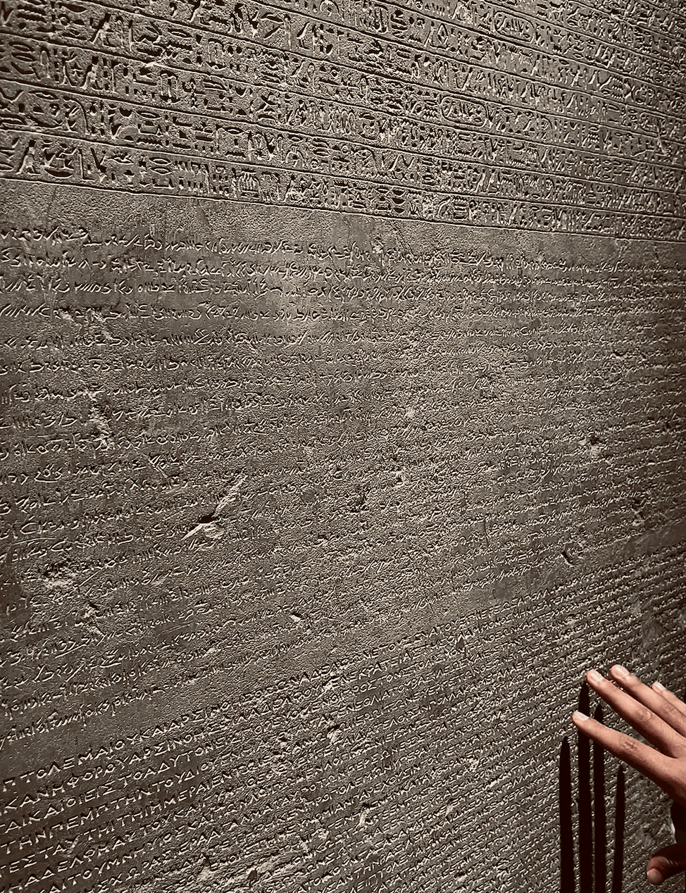 Traveler examining Rosetta Stone replica at Cairo Museum during educational tour