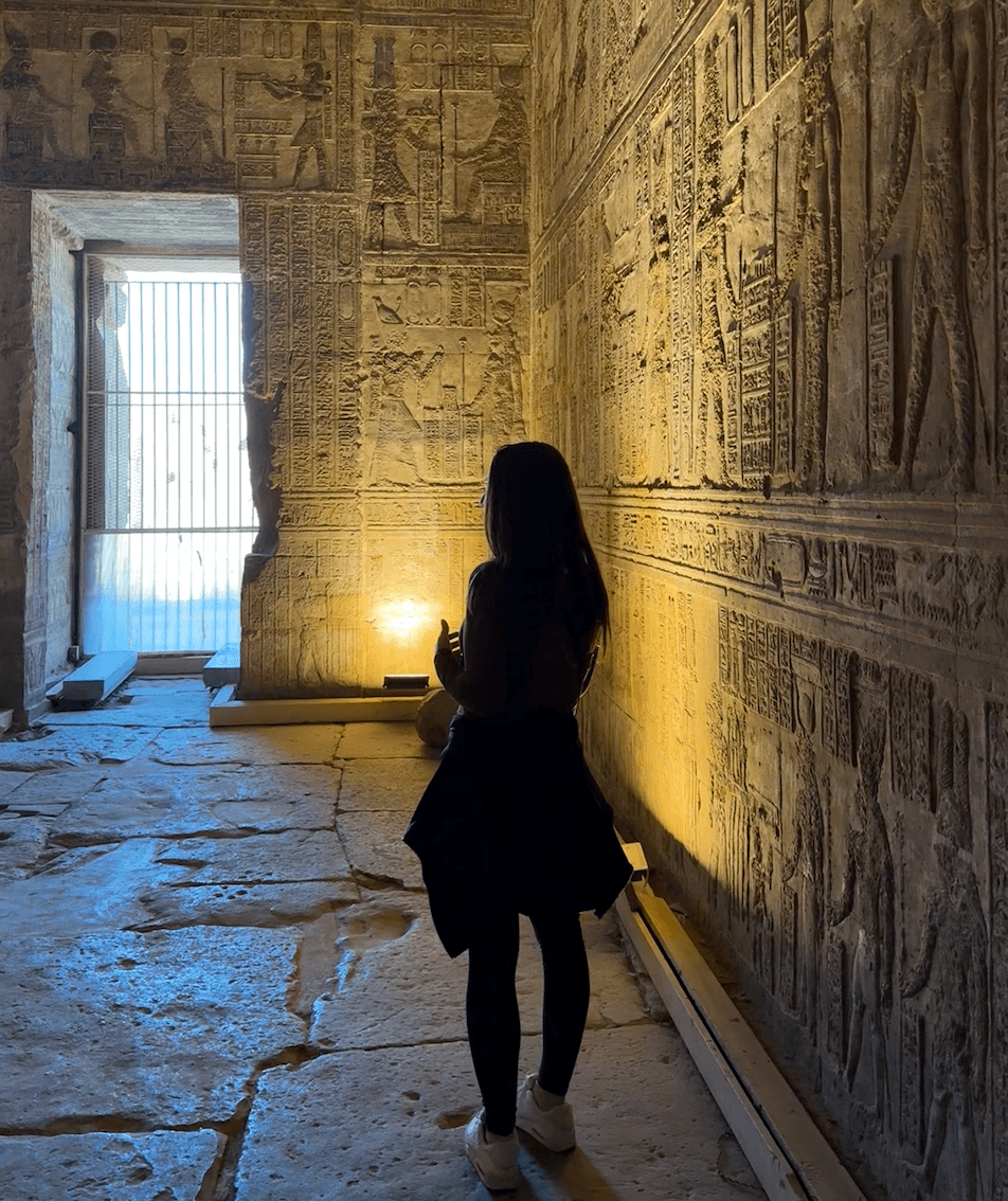 Traveler exploring ancient hieroglyphics inside Dendera Temple, Egypt