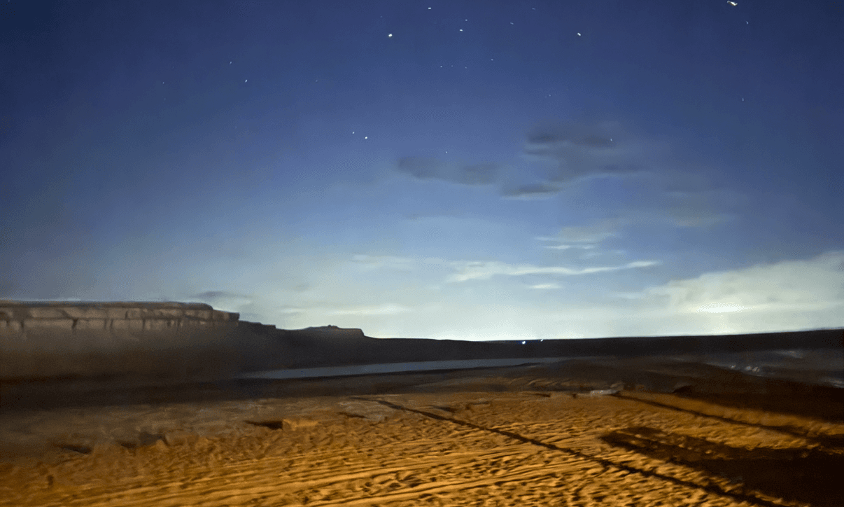 Desert camping at twilight with golden sand dunes and dramatic evening sky in Fayoum, Egypt