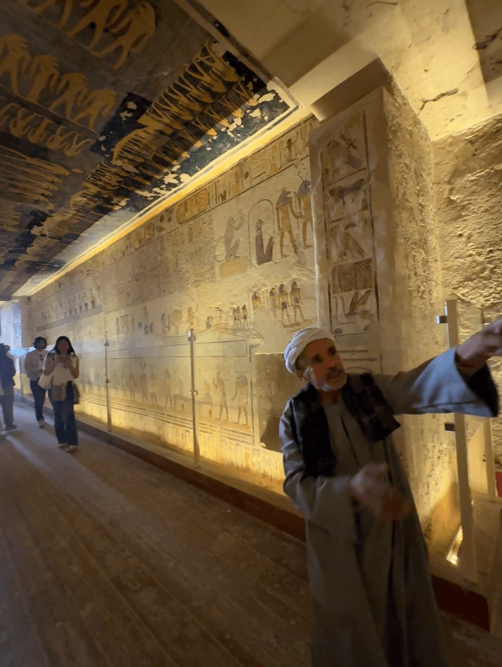 Private tour guide in Valley of the Kings tomb with vibrant ancient Egyptian ceiling paintings