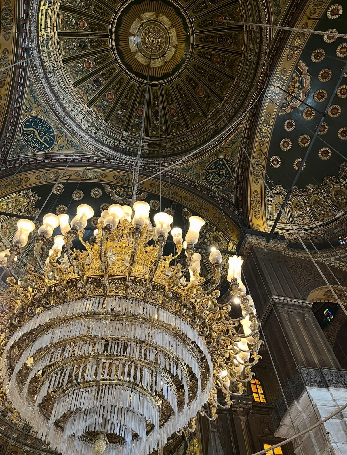 Ornate golden chandelier and decorated dome ceiling inside Muhammad Ali Mosque at the Cairo Citadel