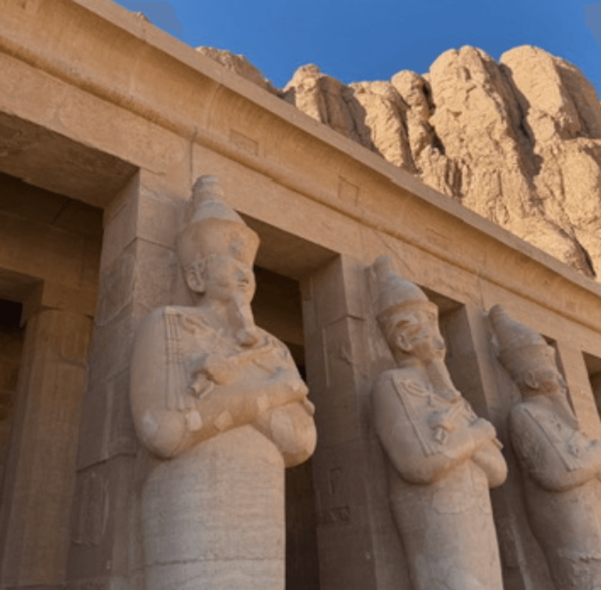 Hatshepsut Temple Luxor - Ancient Egyptian statues with mountain backdrop at Deir el-Bahari mortuary temple complex