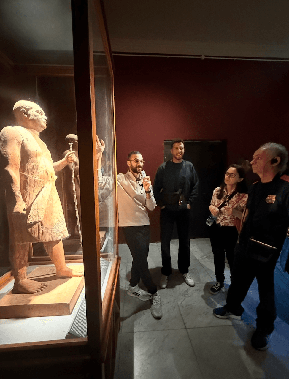Expert guide explaining ancient Egyptian statue at Cairo Museum during private tour