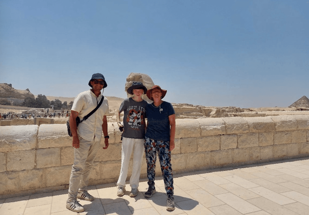 Family enjoying private tour at the Great Sphinx with pyramids of Giza in background