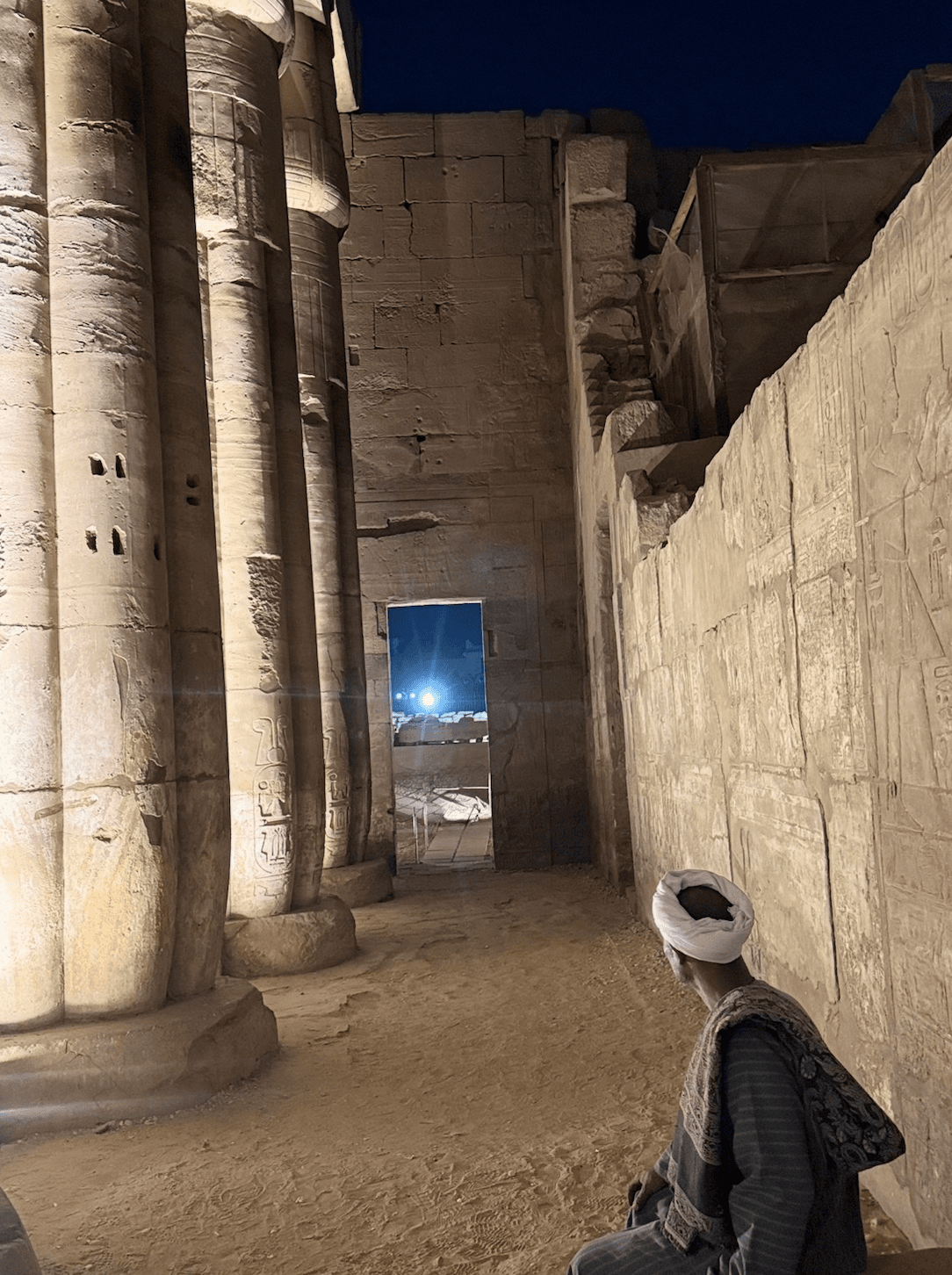 Moon shining through Luxor Temple at night - ancient columns illuminated under starry sky